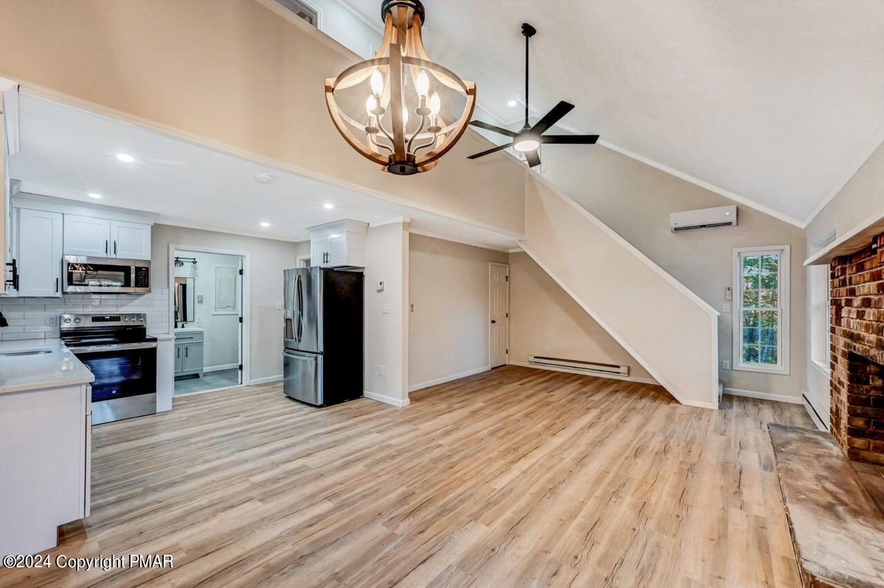 2228 Southport Drive Bushkill, PA 18324 - Photo 5 of 56 a view of a room with wooden floor staircase and kitchen view