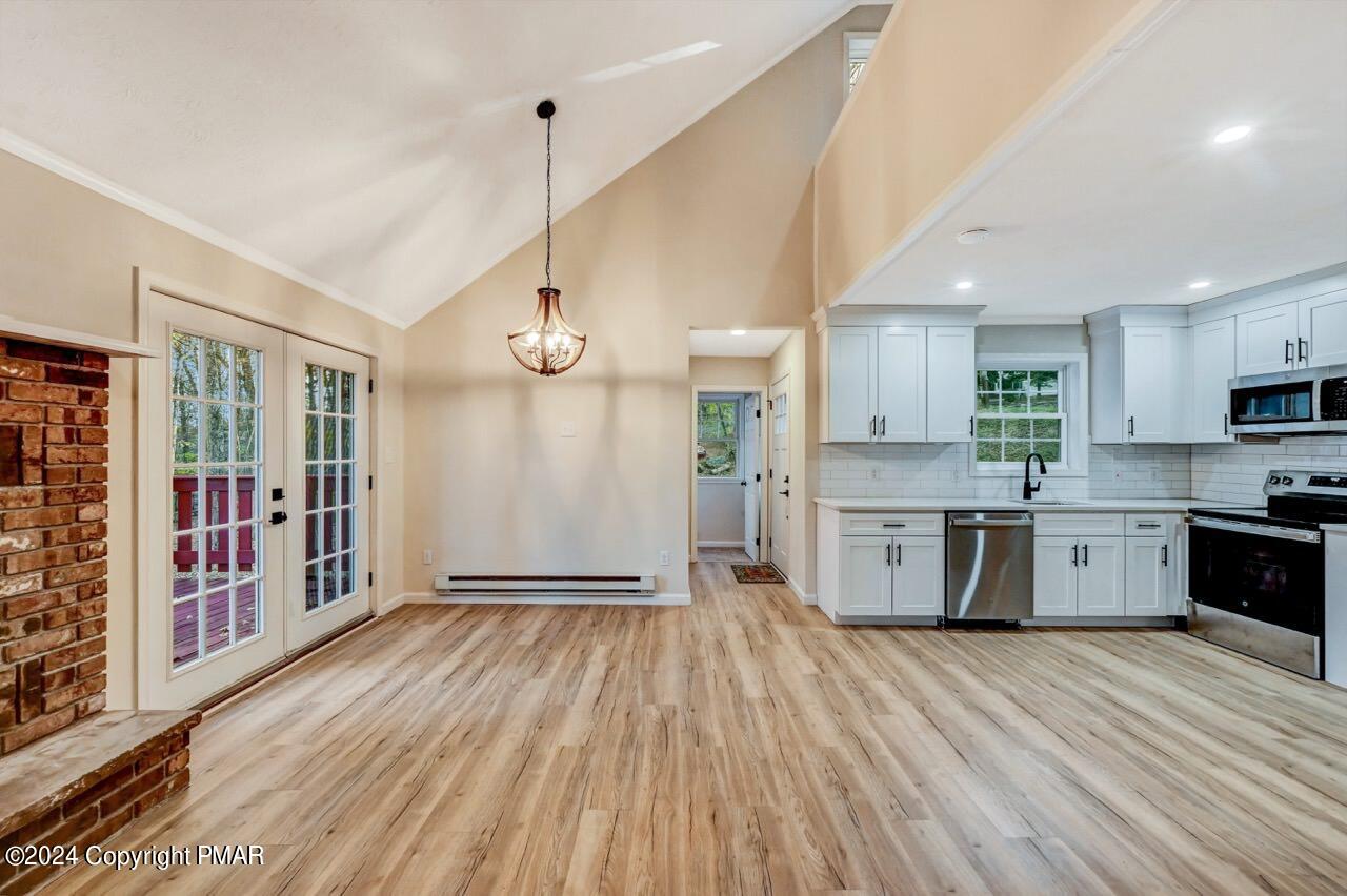 2228 Southport Drive Bushkill, PA 18324 - Photo 7 of 56 a large kitchen with stainless steel appliances a large counter top a refrigerator a stove a sink and a wooden floors