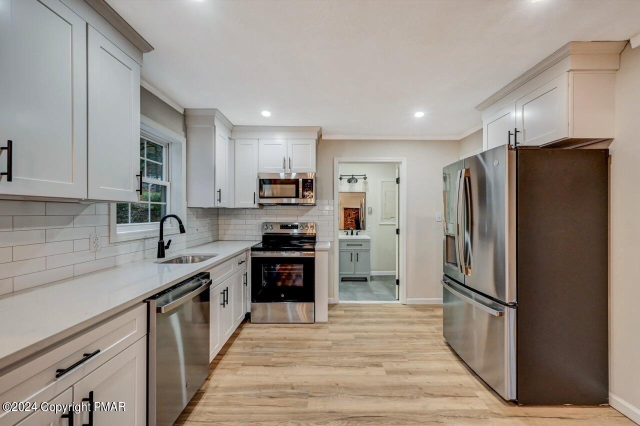 2228 Southport Drive Bushkill, PA 18324 - Photo 9 of 56 a kitchen with stainless steel appliances a refrigerator stove microwave and sink