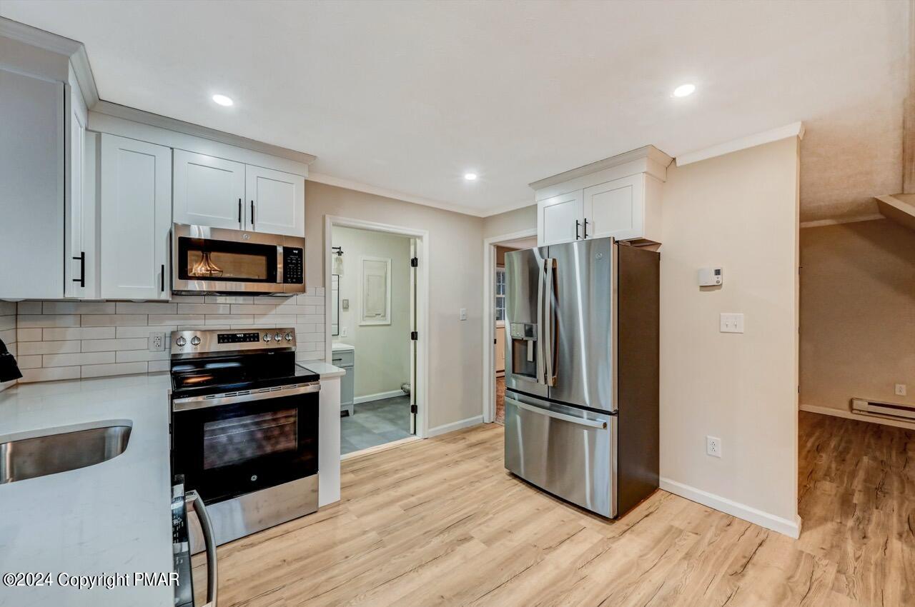 2228 Southport Drive Bushkill, PA 18324 - Photo 10 of 56 a kitchen with granite countertop a refrigerator and a stove top oven