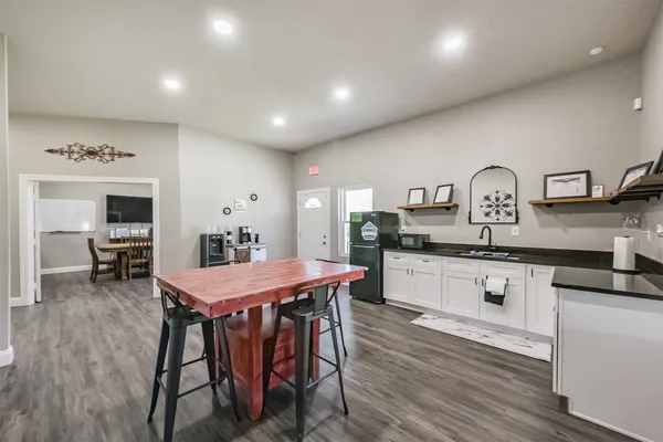 a kitchen with stainless steel appliances granite countertop a kitchen island a stove a table and chairs