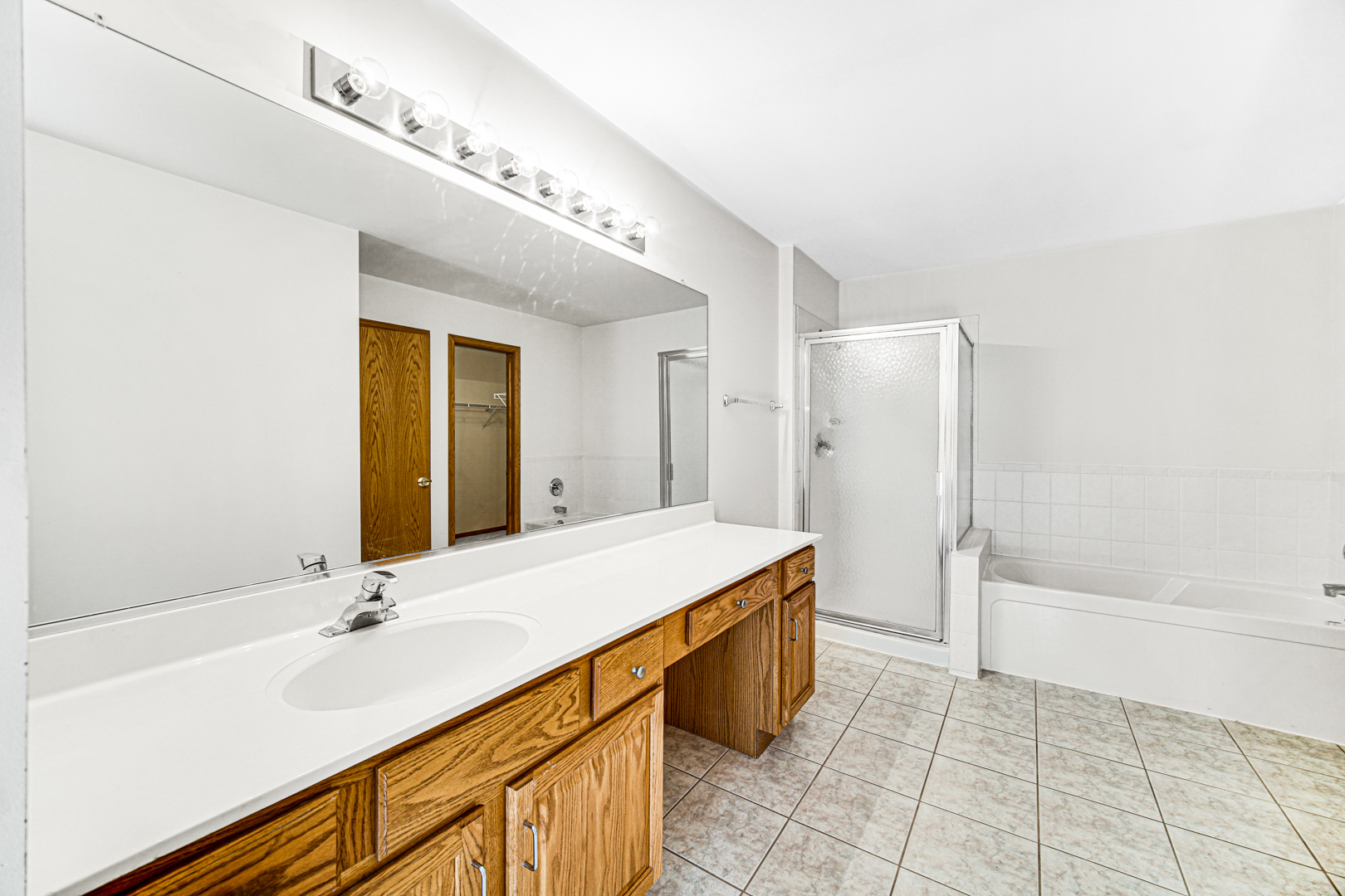 11837 Somerset Road Orland Park, IL 60467 - Photo 19 of 26 a spacious bathroom with a granite countertop sink a toilet a mirror and bathtub