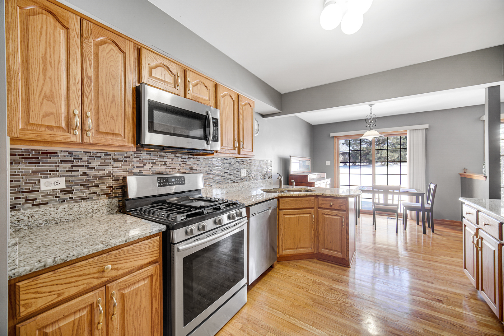 11837 Somerset Road Orland Park, IL 60467 - Photo 8 of 26 a kitchen with granite countertop wooden floors and stainless steel appliances