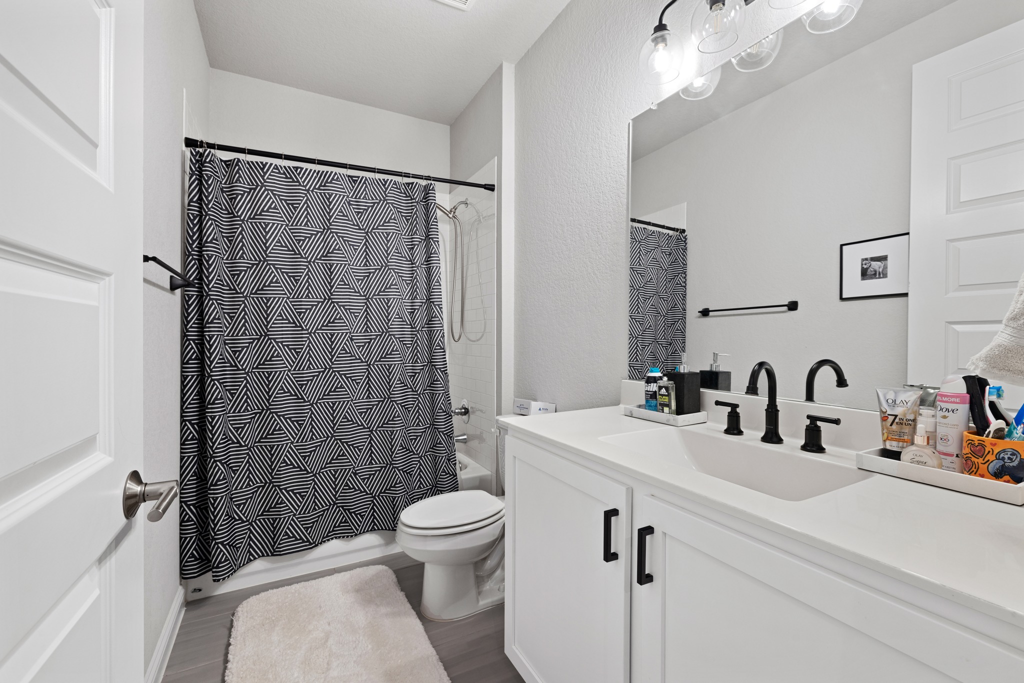 8405 Hubble Walk Austin, TX 78744 - Photo 20 of 36 Bathroom with vanity, shower / bathtub combination with curtain, and dark wood-type flooring