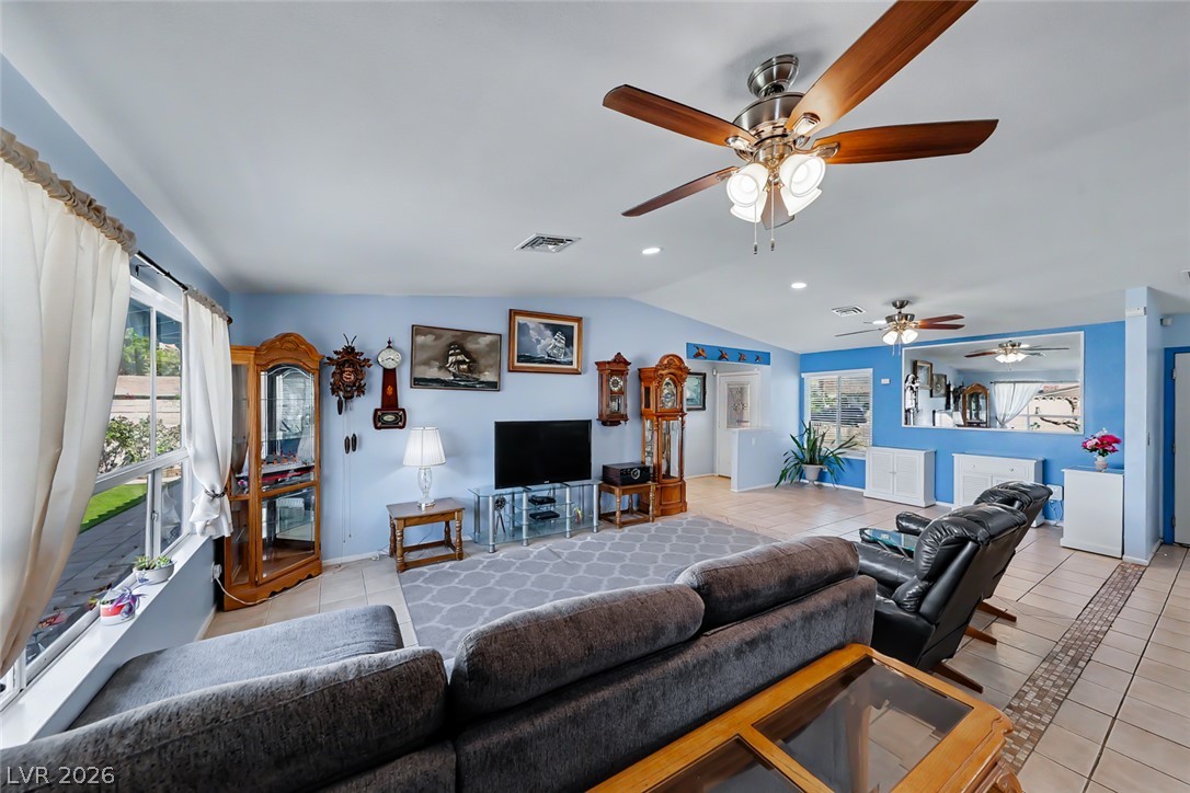 3107 Trueno Road Henderson, NV 89014 - Photo 19 of 37 An inviting family room showcasing lofty vaulted ceilings and light-colored tile flooring.