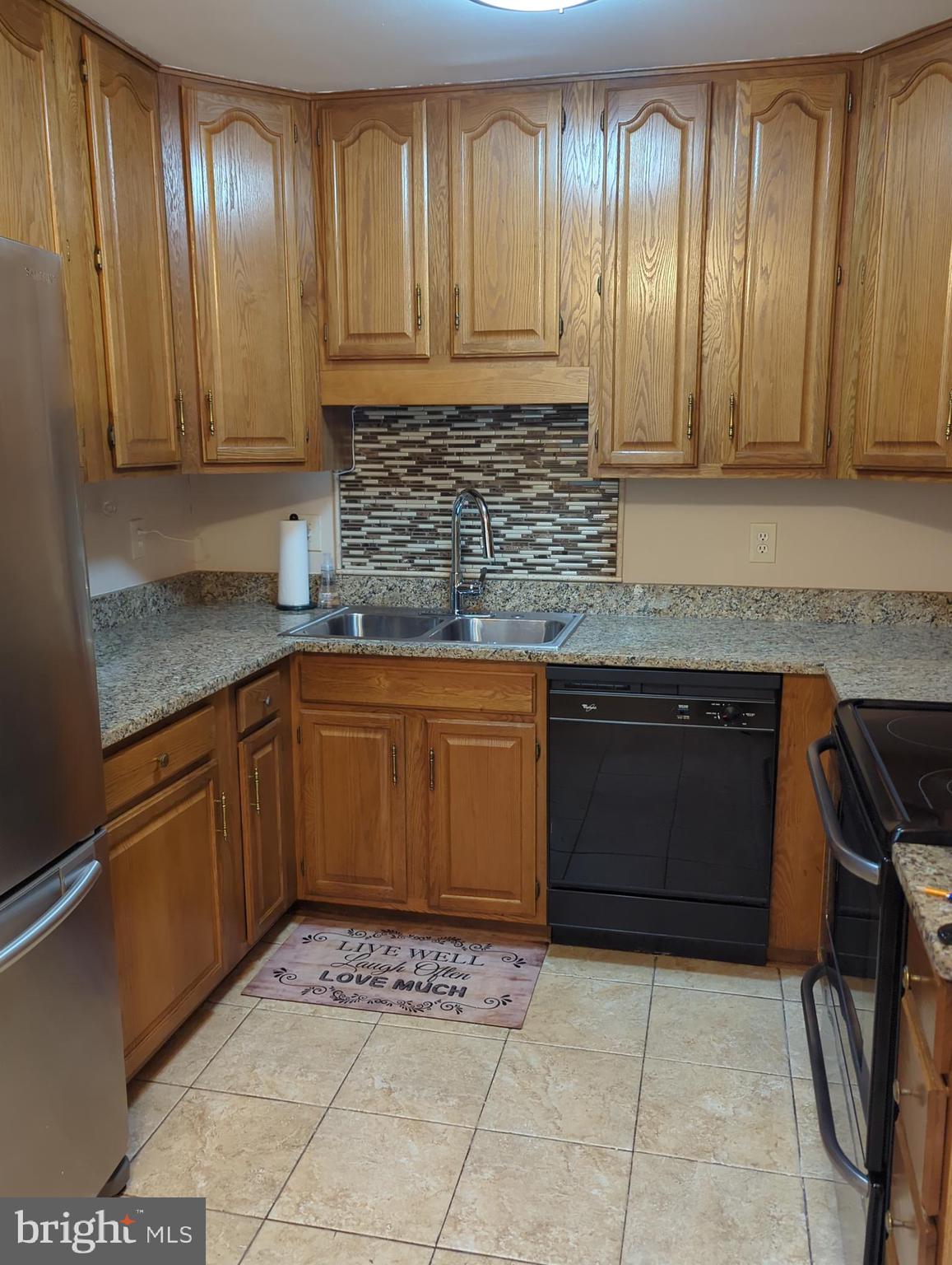 11223 Watermill Lane Silver Spring, MD 20902 - Photo 3 of 20 a kitchen with stainless steel appliances granite countertop a stove a sink and dishwasher wooden cabinets