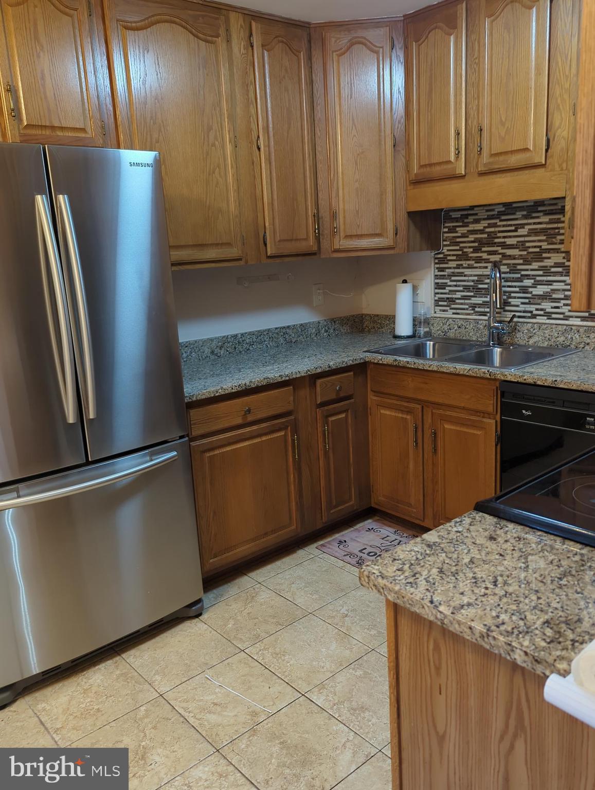 11223 Watermill Lane Silver Spring, MD 20902 - Photo 5 of 20 a kitchen with stainless steel appliances granite countertop wooden cabinets a refrigerator and a sink