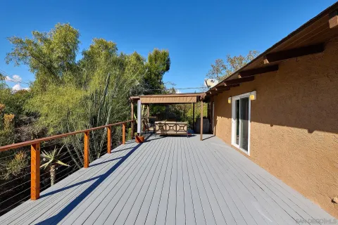 a view of balcony with wooden floor and fence
