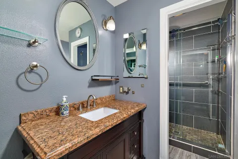 a bathroom with a granite countertop sink and a mirror