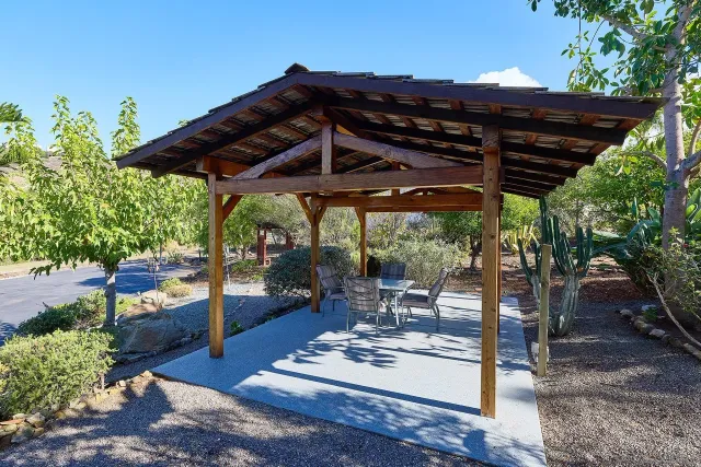 a view of a patio with table and chairs under an umbrella with a small yard