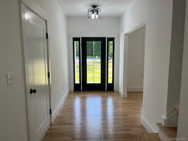 a view of a hallway with wooden floor and a chandelier