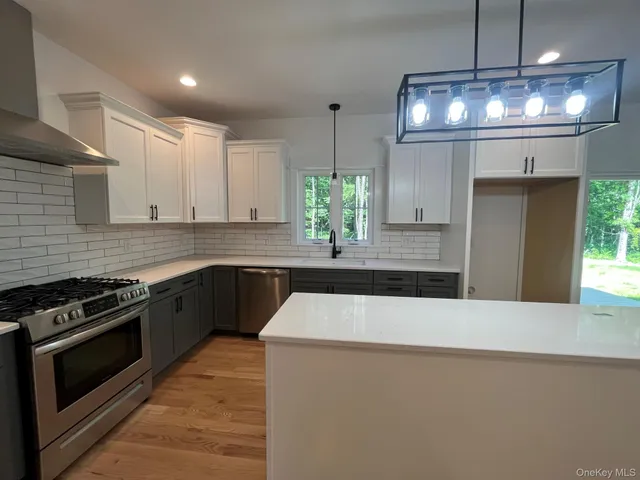 a kitchen with stainless steel appliances granite countertop a sink a stove and a refrigerator