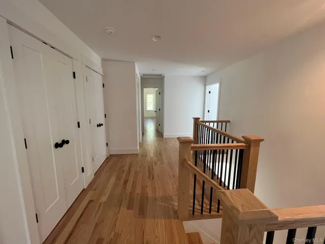 a view of a hallway with wooden floor and staircase