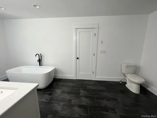 a bathroom with a toilet a sink and mirror