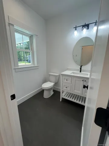 a living room with table chairs and a window
