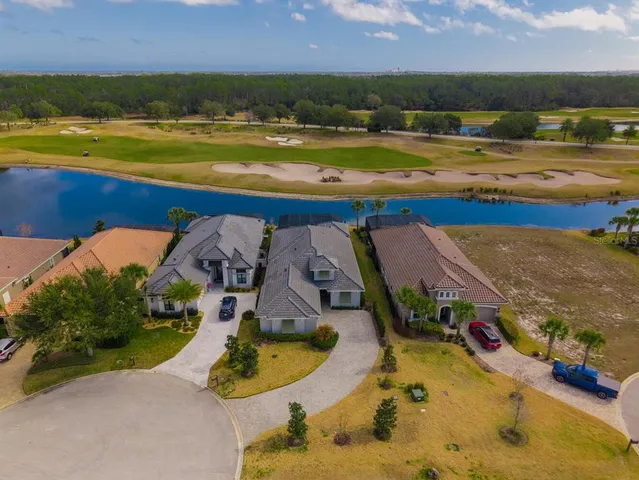 a kitchen with stainless steel appliances kitchen island granite countertop a dining table chairs and a refrigerator