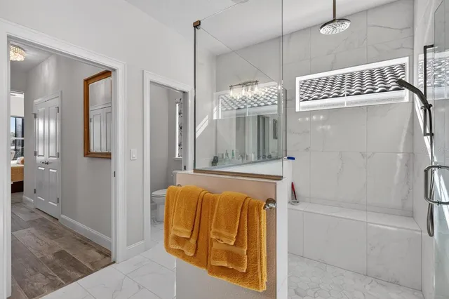 a very nice looking living room with a dining table a chandelier and a rug
