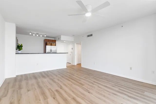a view of a kitchen with wooden floor and a ceiling fan