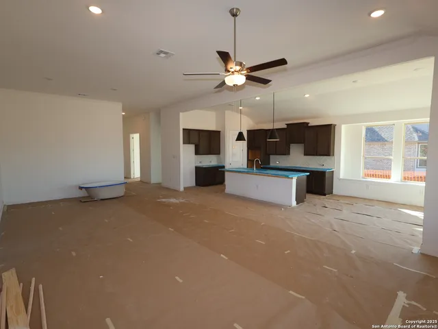 an empty room with a window and a fan