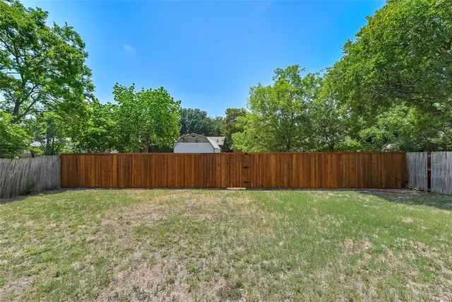 a view of small yard with wooden fence
