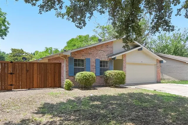 a view of a house with a yard and potted plants