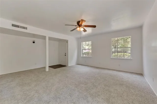 a view of a room with a window and a ceiling fan