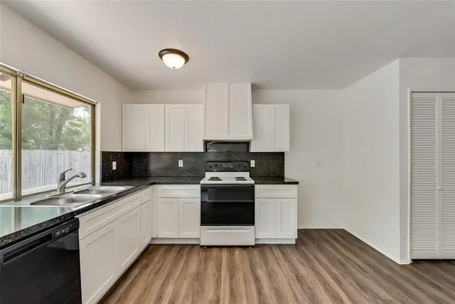 a kitchen with a sink a stove and cabinets