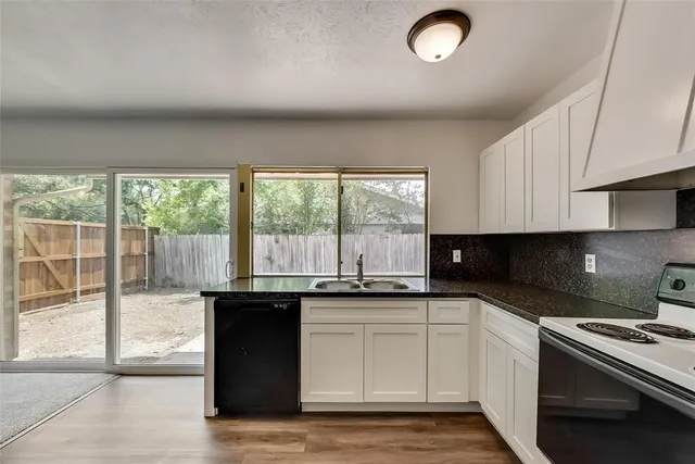 a kitchen with granite countertop a sink and a stove