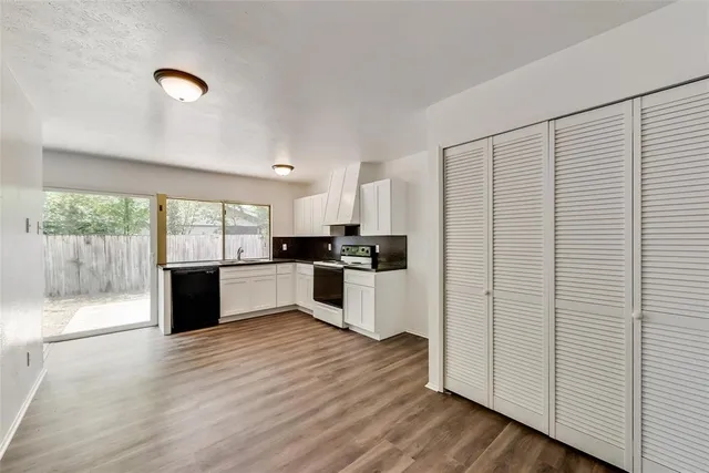 a kitchen with stainless steel appliances kitchen island wooden cabinets and wooden floor