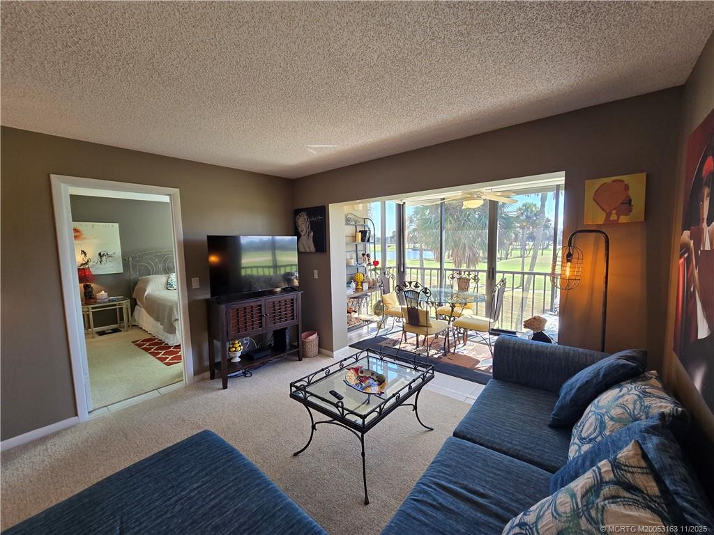 5564 Northeast Gulfstream Way Stuart, FL 34996 - Photo 16 of 41 a living room with furniture and a flat screen tv