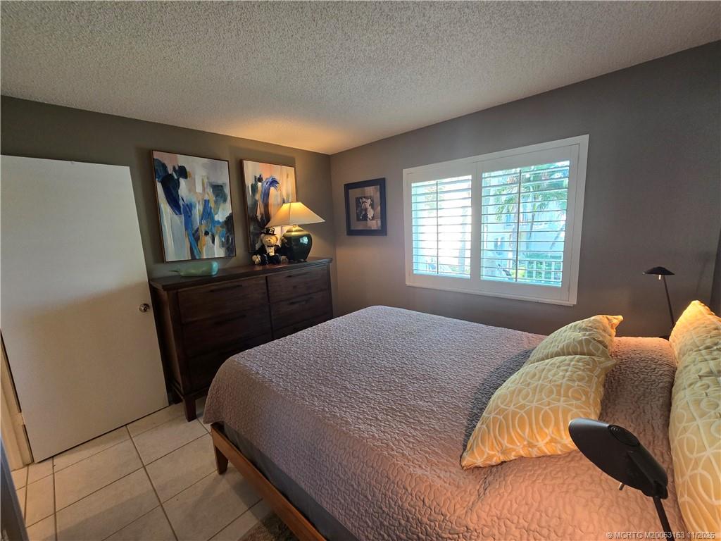 5564 Northeast Gulfstream Way Stuart, FL 34996 - Photo 23 of 41 a bedroom with a bed and window