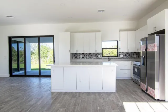a kitchen with a refrigerator a sink and cabinets
