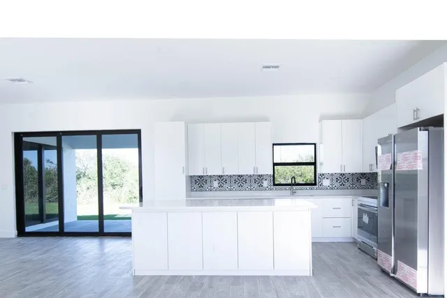 a kitchen with stainless steel appliances a refrigerator and a stove top oven