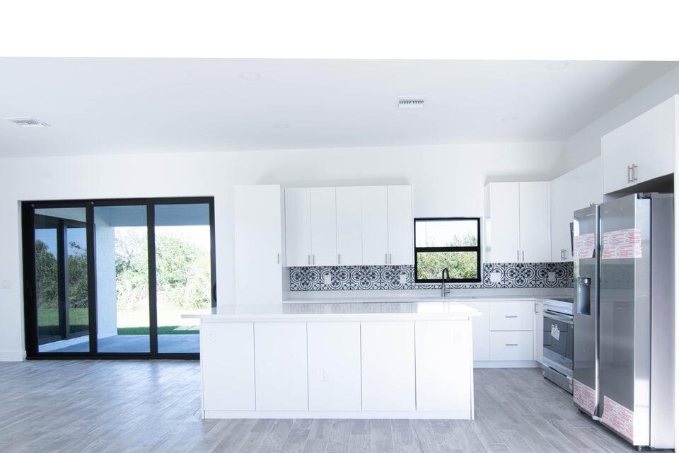8126 Thruso Road Port Charlotte, FL 33981 - Photo 16 of 32 a kitchen with stainless steel appliances a refrigerator and a stove top oven