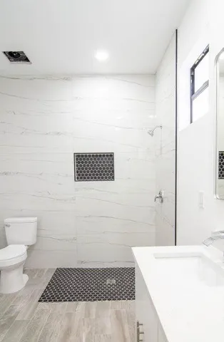 a bathroom with a sink a toilet and shower