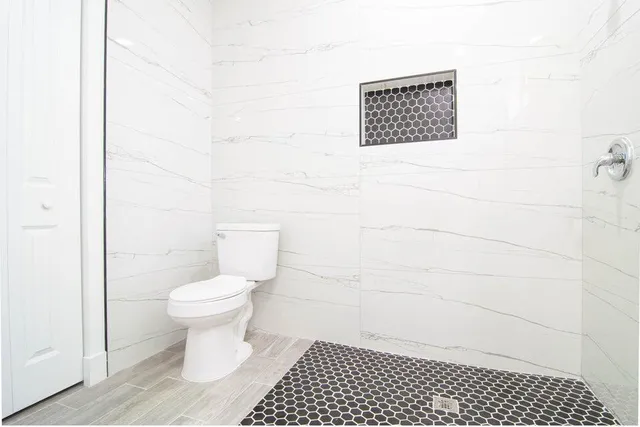 a bathroom with a toilet a sink and a shower