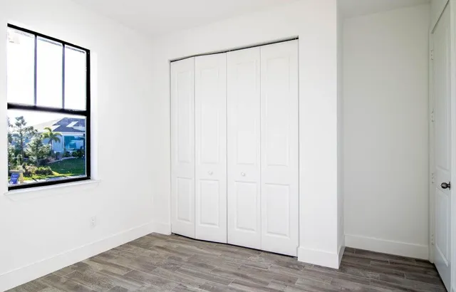a view of a small space with wooden floor and a window