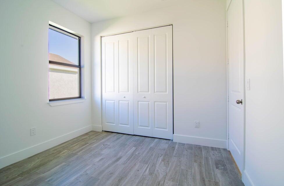 8126 Thruso Road Port Charlotte, FL 33981 - Photo 24 of 32 an empty room with wooden floor and windows