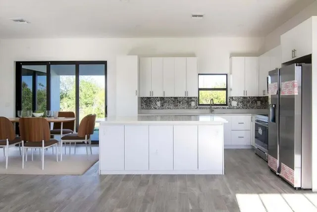 a kitchen with refrigerator cabinets dining table and chairs
