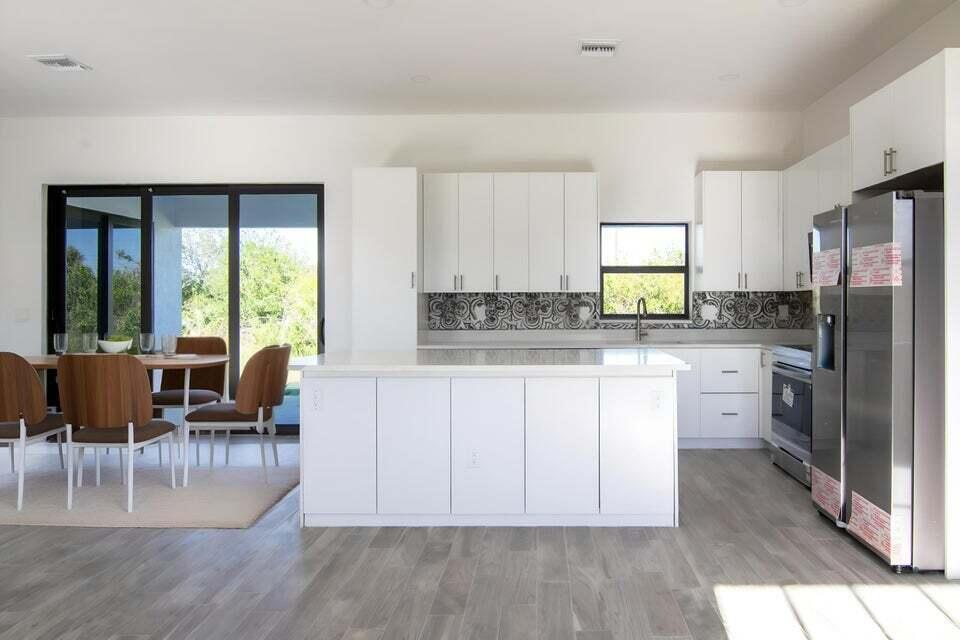 8126 Thruso Road Port Charlotte, FL 33981 - Photo 6 of 32 a kitchen with refrigerator cabinets dining table and chairs