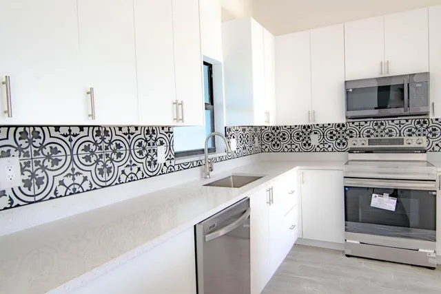 a kitchen with stainless steel appliances granite countertop a sink and a stove