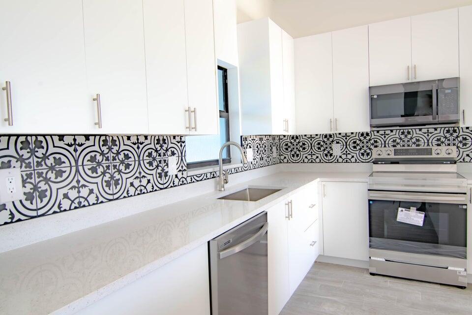 8126 Thruso Road Port Charlotte, FL 33981 - Photo 8 of 32 a kitchen with stainless steel appliances granite countertop a sink and a stove