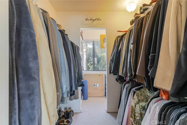a view of walk in closet with clothes and shoes