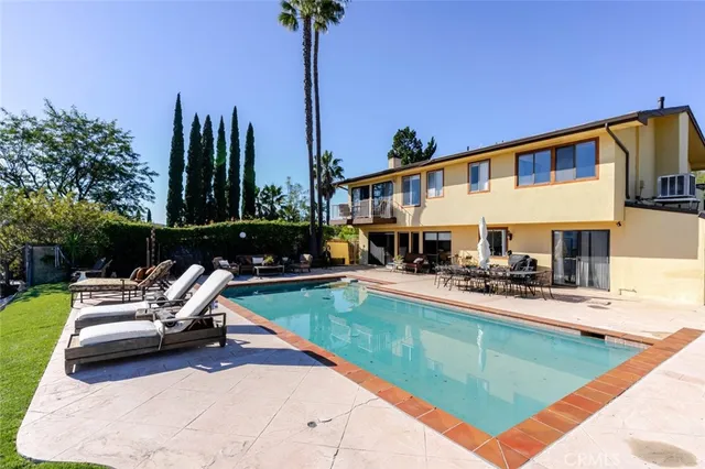 a view of a house with swimming pool and sitting area