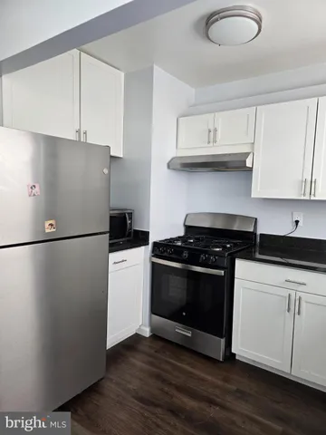 a kitchen with a refrigerator stove and white cabinets