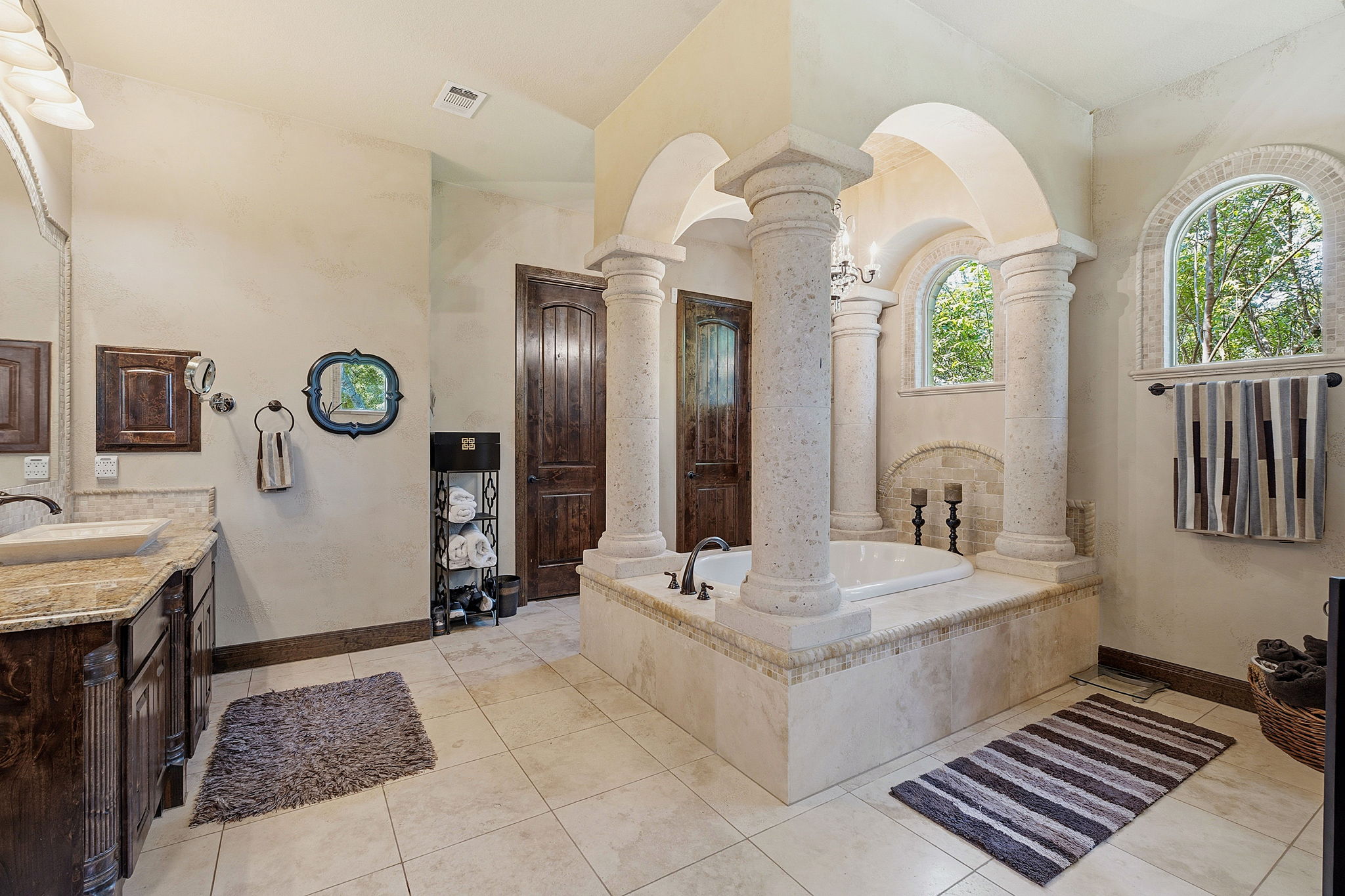 816 Brave Face Street Leander, TX 78641 - Photo 18 of 40 Ornate columns and arched windows frame a luxurious soaking tub in this primary bathroom oasis.