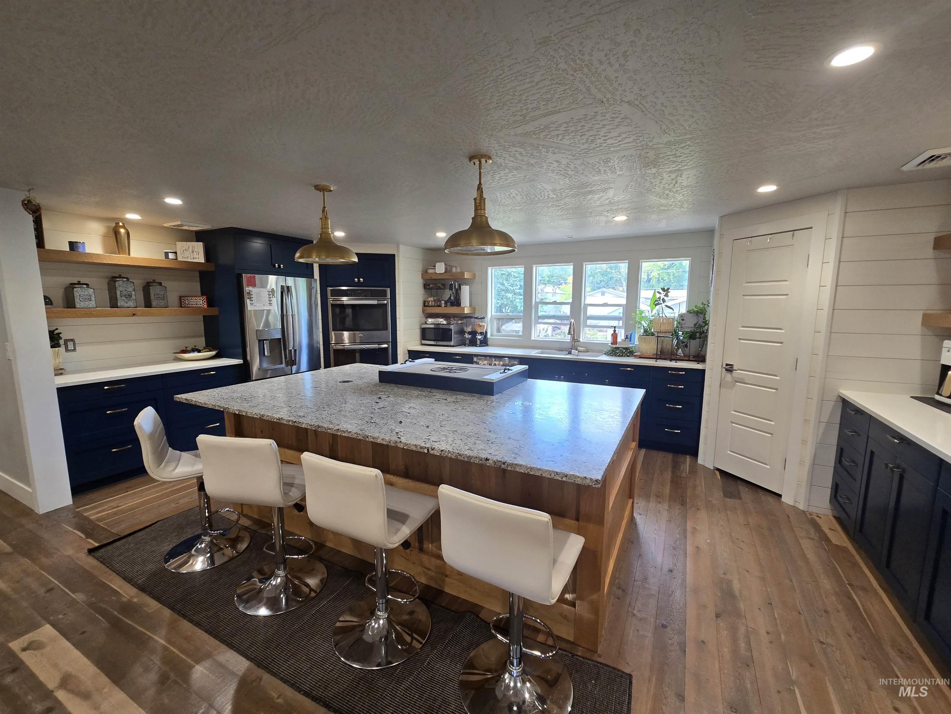 1265 West 1st Street Weiser, ID 83672 - Photo 10 of 23 Kitchen featuring open shelves, pendant lighting, a kitchen island, blue cabinets, and recessed lighting