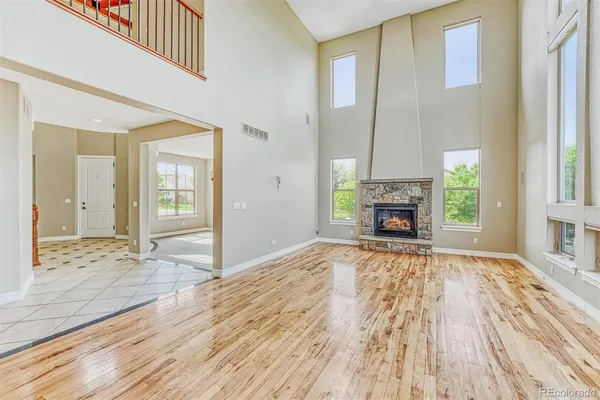 a view of empty room with wooden floor and fireplace