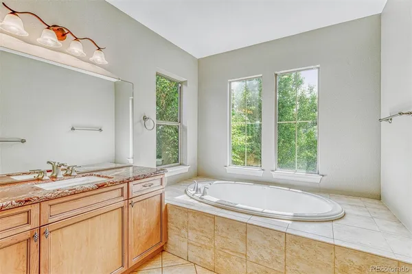 a bathroom with a granite countertop sink and a large mirror