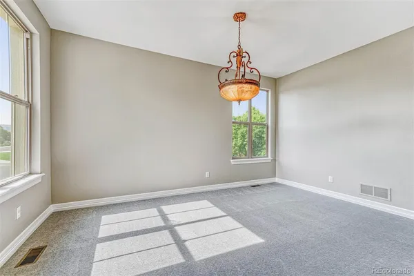 an empty room with windows and chandelier